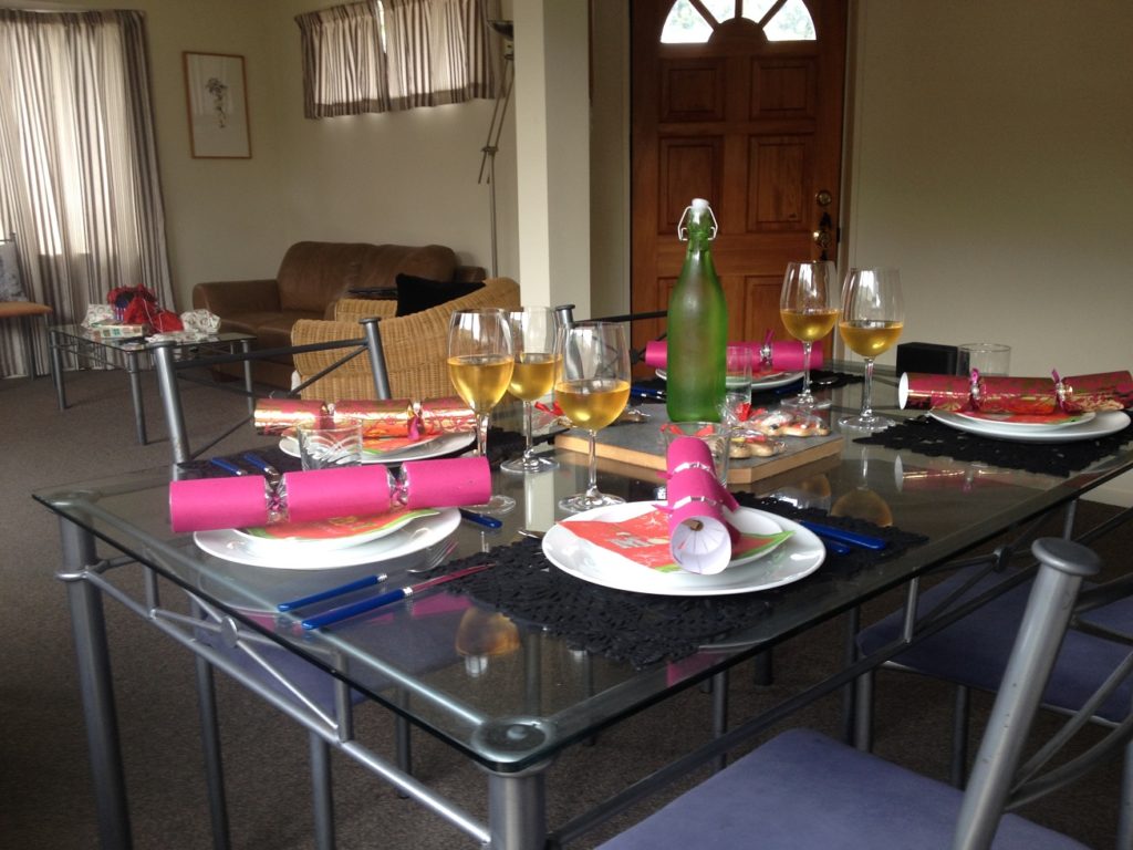 Table de Noël avec du Sauternes dans les verres et des cadeaux au fond